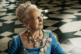 Queen Margrethe of Denmark looks off to the upper right, wearing a pearl parure of tiara, necklance, earrings, and brooch, the sash of the order of the elephant, and two family orders.