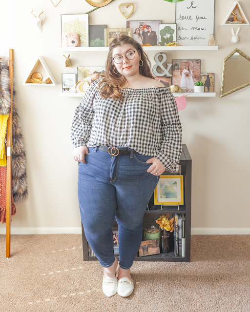 An outfit consisting of a gingham off the shoulder blouse with long angel sleeves, tucked into dark wash high waist skinny jeans and white mules.