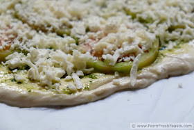 green tomato pizza with pesto and feta ready to be baked