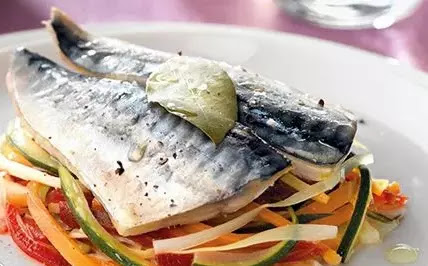 Dos filetes de caballa sobre una cama de verduras y cocidas en horno al papillote