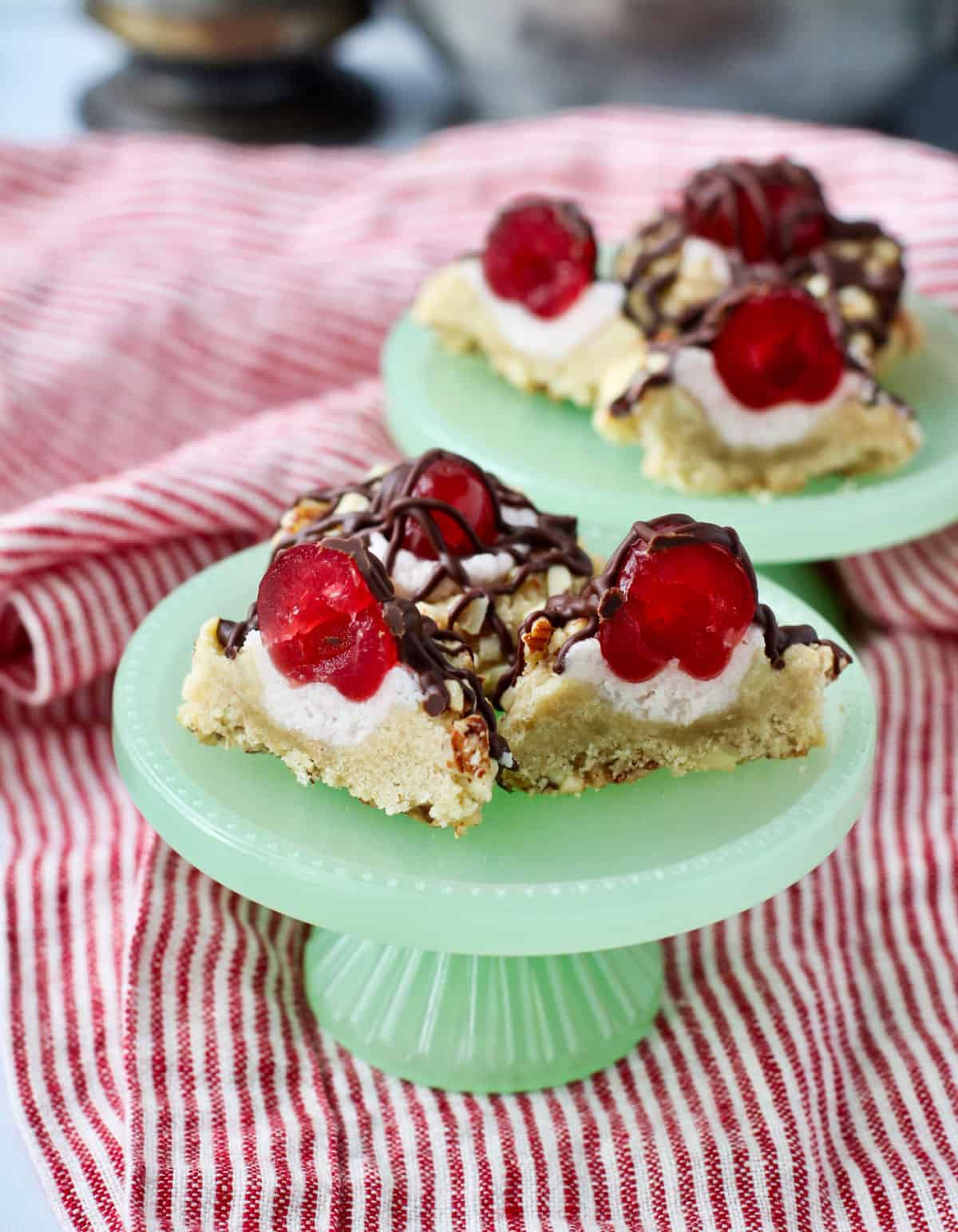 Chocolate Covered Cherry Cookies cut in half on a green mini cake stand.