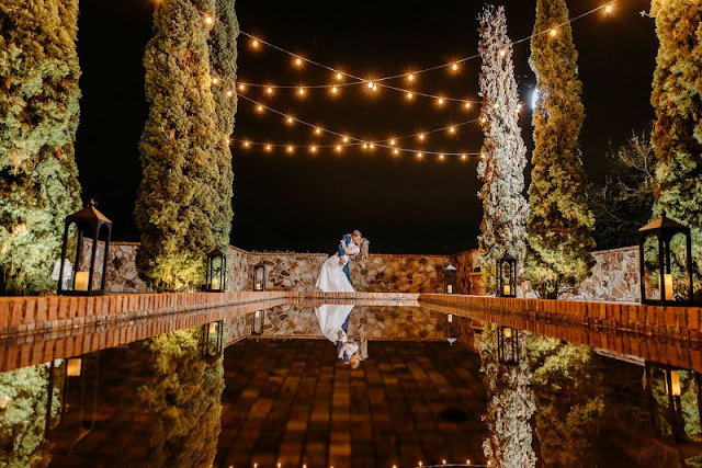 groom dipping bride at bella collina at night with market lighting