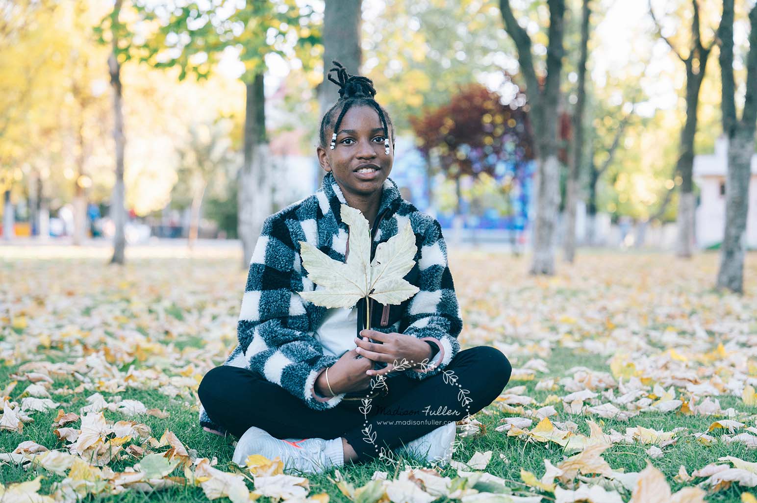 Child Sitting With Fall Leaves