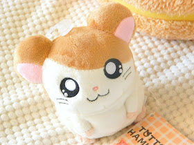 A photo of an orange and white hamster plushie