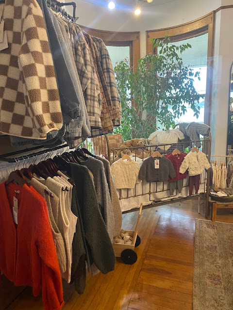 racks of clothes and baby crib