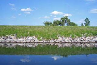 A view of the lake reflecting clear blue of the partly cloudy sky.