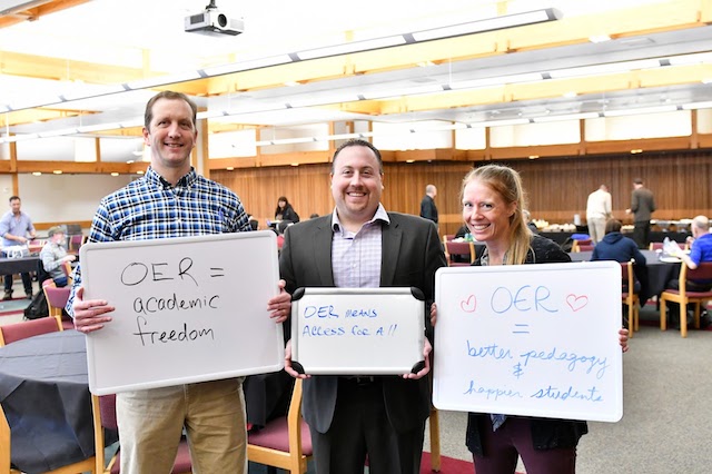Three teachers holding up signs about OER