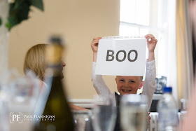 son holding a sign saying boo during wedding speech 