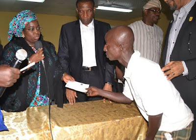 an old citizen of lagos state receiving his cheque from the lagos state deputy governor
