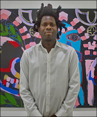 Bradley standing in front of his Pitt Rivers art