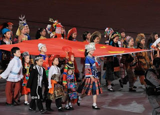 jeunes figurants représentant les 56 ethnies du pays portent le drapeau chinois