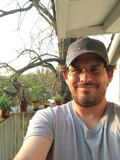 Selfie on my balcony with some of my houseplants behind me.