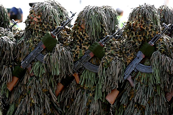 Soldiers wearing ghillie camouflage suits which simulate heavy foliage 