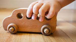 A Child and a Wooden Toy Barn