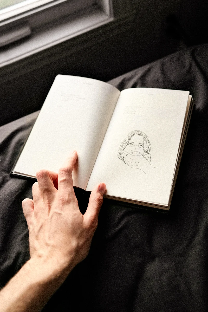 an opened sketchbook with creative illustrations on its pages