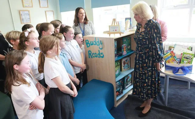 Queen Camilla wore a v-neck colourful feather printed midi dress. She also donned a pair of classic black pumps