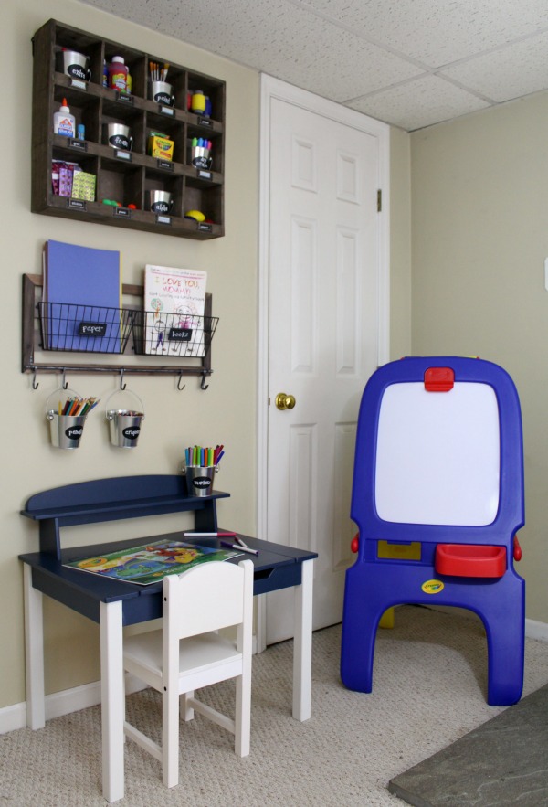 Organized art station for kid's art and craft supplies: Desk, chair, easel, and hanging supply storage