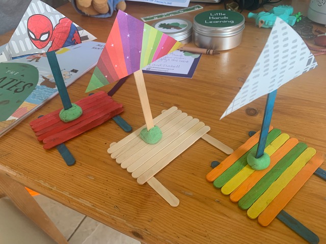 Three boats made out of lolly sticks, with playdough sails