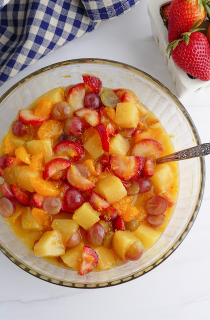 Lemon Vanilla Pudding Fruit Salad in a glass bowl with gray marble background.