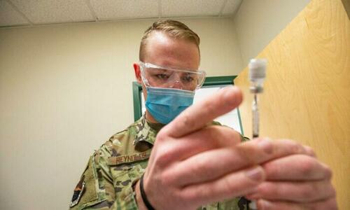 A U.S. Air Force staff sergeant handles a Pfizer COVID-19 vaccine at a clinic in Massachusetts on Feb. 16, 2021. (Joseph Prezioso/AFP via Getty Images)