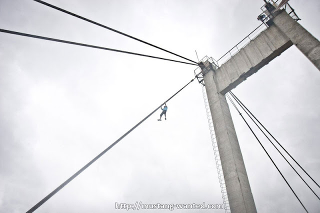 Man climbing on the steel bridge wire 