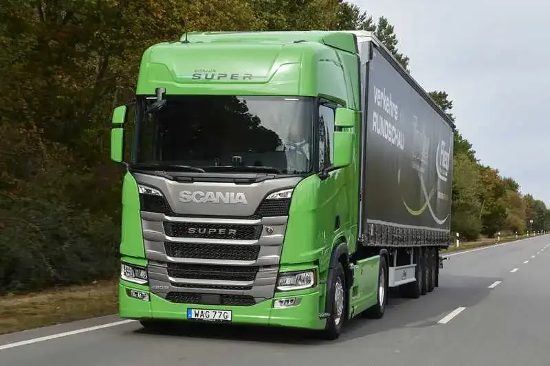 Scania 460 R SUPER verde puxando carreta sider em uma rodovia europeia