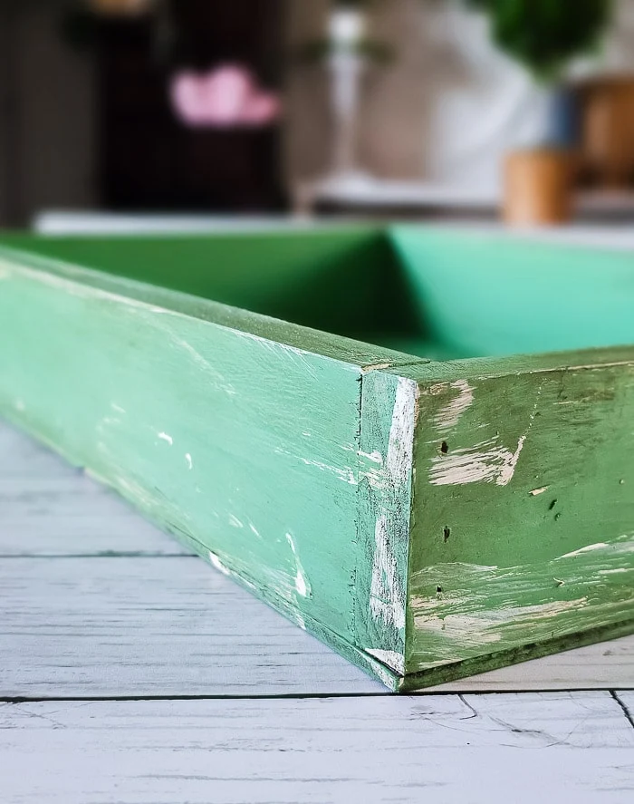 close up of green wood crate, layers of paint and wax