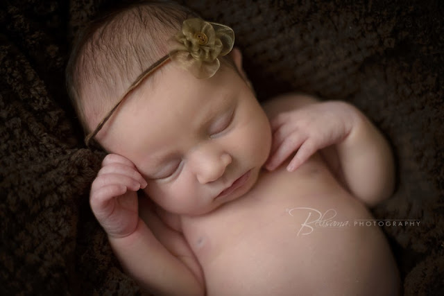 close-up of newborn baby sleeping on brown blanket