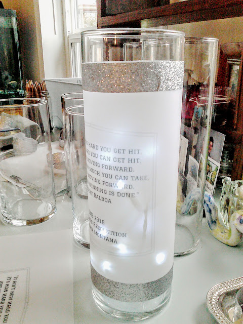 vellum wrap with text wrapping a tall vase, silver glitter tape accent