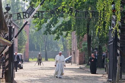 Pope Francis walks through the entrance of the former Nazi death camp of Auschwitz