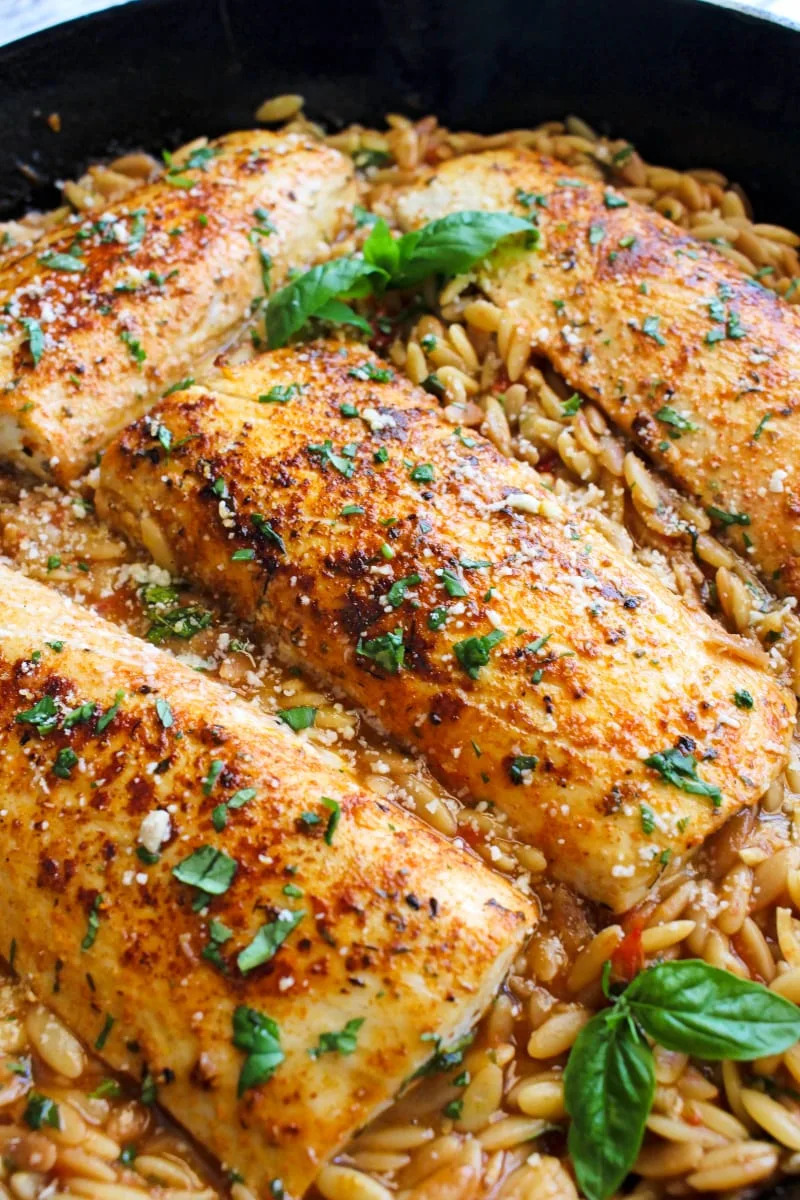 Side view of Mahi Mahi and Tomato Basil Orzo in a cast iron skillet.