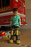 David Cheng, 3, is trying out fire fighter bunker rubber boots for size at the Ballston Fire Station in Arlington