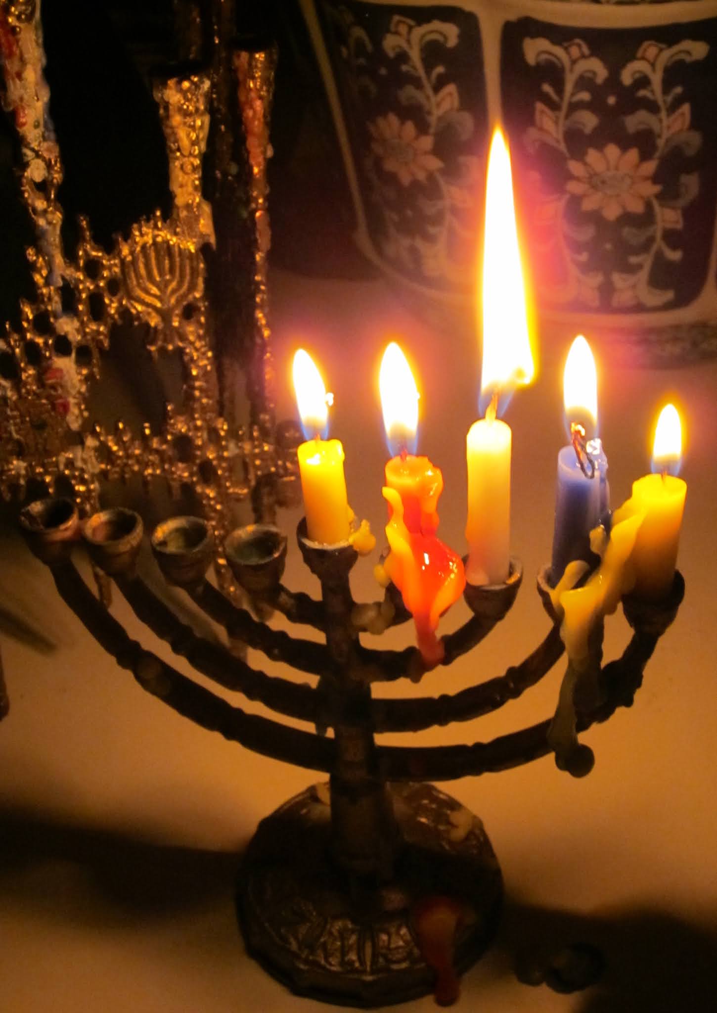 photo of a small traditional Chanukah menorah with shamash, first, second, third, and fourth candles lit