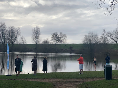 Mensen in badkleding aan de waterkant