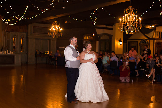  Cassie and Wyatt tied the knot at The Palace Event Center, in Yukon, OK, on July 15, 2017.   The venue’s magnificent wood entry doorways, outside rock façade, and adjacent country landscape provided the perfect backdrop to photograph the first look and pictures of the jovial wedding party.  The venue was spacious, which allowed us to sneak in a few pre-dressed shots of the girls in their “Wedding Tribe” t-shirts.     Cassie’s elegant, form-fitting, strapless, satin wedding dress overlaid with lace and sequins looked like it was made especially for her.  Wyatt was quite the Knight in Shining Armor dressed in his navy suit, grey vest, and burgundy tie.  The four beautiful bridesmaids wore matching full-length, flowing, burgundy gowns, slit at the knee.  Cassie’s gorgeous bouquet was composed of baby’s breath, peonies and ranunculus in rich hues of vibrant burgundy, red, pink, burnt orange, and yellow gold.  To add to the excitement of the day, their son had a special assignment—carrying the sign down the aisle that stated, “Daddy, Here Comes Our Girl.”     The venue’s grand ballroom, with it’s beautiful chandeliers and romantic lighting, was the perfect backdrop for the couple’s reception.  Candlelight, flowers, and twinkle lights adorned the nuptial stage, and after the vow exchange, Cassie and Wyatt participated in their first dance.  Guests were invited to enjoy the buffet, the cutting of the cake, and the toasts by the best man and bridesmaid.  Chairs were quickly removed from the dance floor, and while almost everyone spent the rest of the afternoon relaxing, dancing and socializing, there was a particularly fun-loving group of guests who decorated the bride and groom’s Jeep with sayings, crepe paper, and a car filled-to-the-brim with balloons!        Cassie stated that the best part of the wedding was being able to see so many family and friends at the reception having fun and enjoying themselves.  She said, “If we had it to do over, we wouldn’t do anything differently…it was perfect for both of us!”     It was a pleasure to capture the special moments of this memorable wedding day for Cassie and Wyatt, and we wish them a lifetime of love and happiness. 