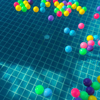 Image of coloured balls floating. Fun for newborns swimming