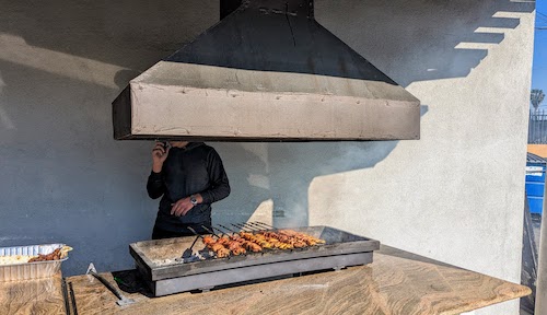 The outdoor grill with hood and cooking skewers of meat
