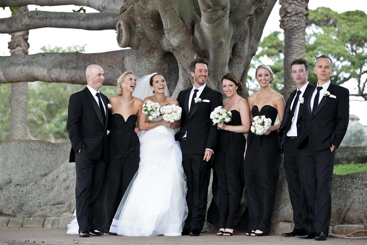 The bridal party photo shoot took place by the water The grooms suit was