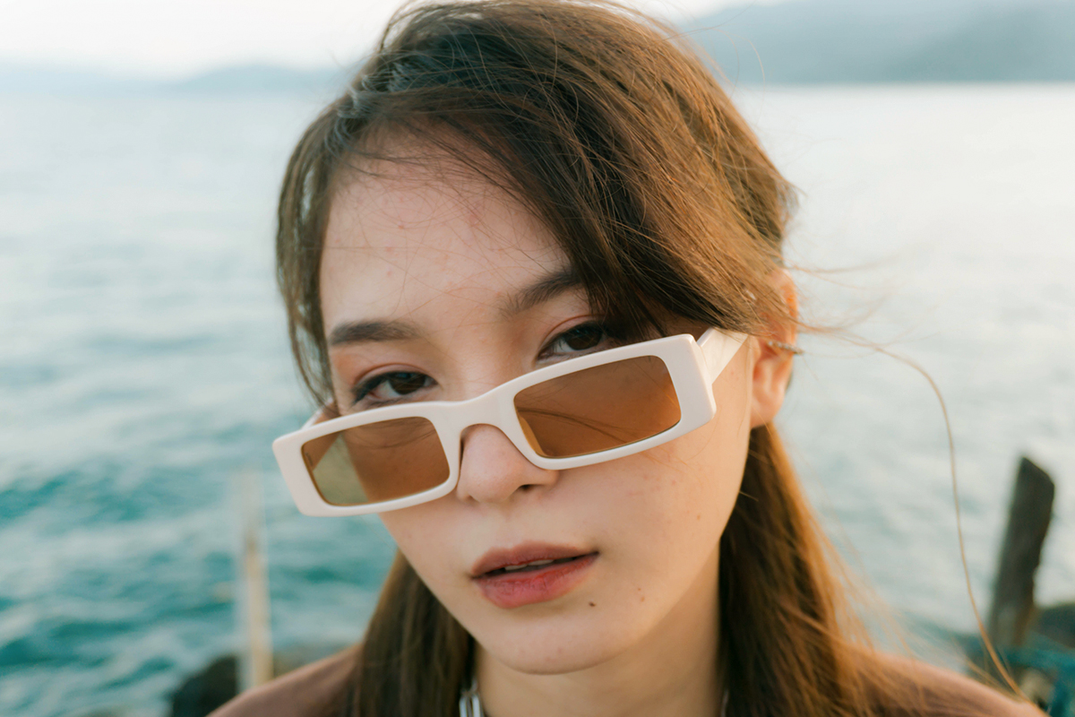 portrait of a young, beautiful woman in sunglasses with oversized frames