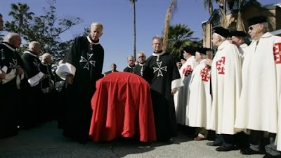 The coffin of Carl Jr. founder Carl Karcher passes through an honor guard representing the Knights and Dames of Malta, left, in black, and the Knights and Ladies of the Holy Sepulchre, right, in white at the funeral services for Karcher at St. Boniface Catholic Church in Anaheim, Calif