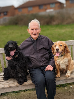 My dad sitting on a park bench between Boris and Eko as they all look towards the camera