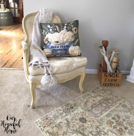 bergere chair knit throw tassels velvet pumpkin pillow stenciled box spindles white birch logs