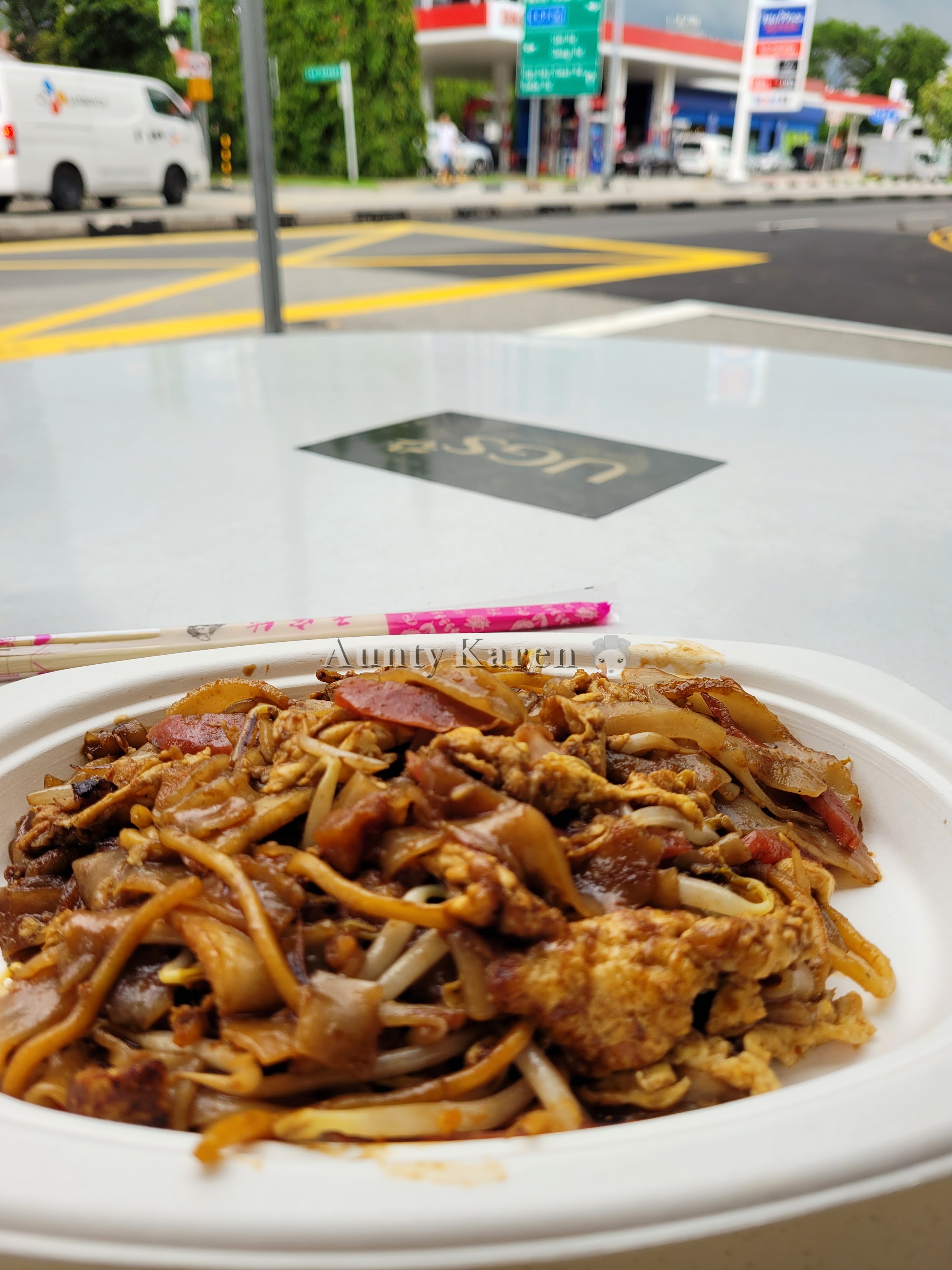 Plate of Char Kway Teow from Katong Jago Carrot Cake with background of road junction