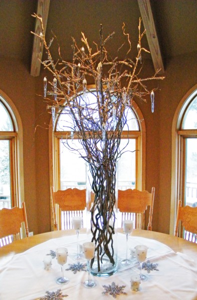 A tall cylinder vases was filled with branches that were encrusted with 