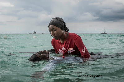 color photograph of female swim instructor teaching student to float