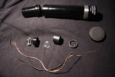 photograph finder scope disassembled beside thin copper wire