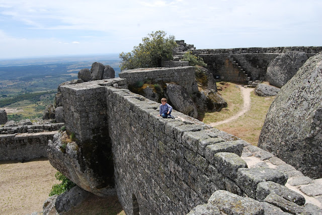 Vista de las murallas del castillo de Monsanto con un niño subido en lo alto