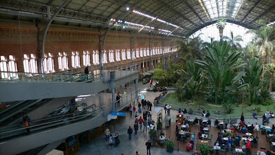 Madrid Atocha (Spanish: Estación de Madrid Atocha, also named Madrid Puerta de Atocha) is the largest railway station in Madrid. It is the primary station serving commuter trains (Cercanías), intercity and regional trains from the south, and the AVE high speed trains from Barcelona (Catalonia), Saragosse (Aragon), Seville (Andalusia) and Valencia (Levante Region). These train services are run by the Spanish national rail company, Renfe. The station is in the Atocha neighborhood of the district of Arganzuela. The original façade faces the Plaza del Emperador Carlos V, a site at which a variety of streets converge, including the Calle de Atocha, Paseo del Prado, Paseo de la Infanta Isabel, Avenida de la Ciudad de Barcelona, Calle de Méndez Álvaro, Paseo de las Delicias, Paseo de Santa María de la Cabeza, and Ronda de Atocha.