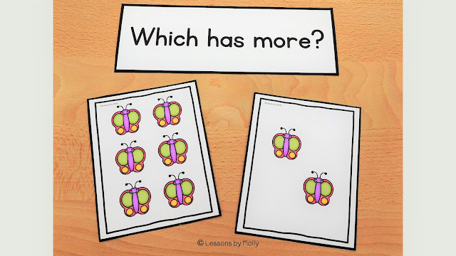 There are two picture cards displayed side by side. One card features six butterflies, while the other card displays two butterflies. A question on the photo prompts, "Which has more?"