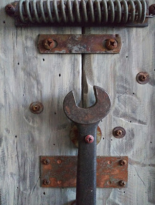 detail showing aged wrench and spring on new wood sculpture